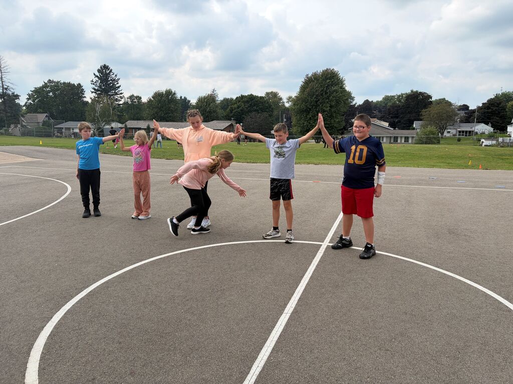 5th grade students play human chain game outside