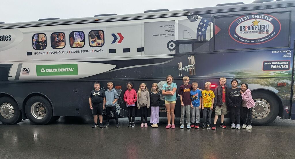 4th graders take a picture out in front of the STEM shuttle