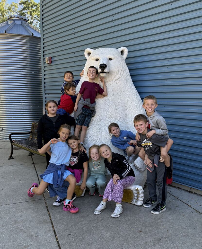 students pose for a picture by a polar bear statue at Henry Vilas Zoo