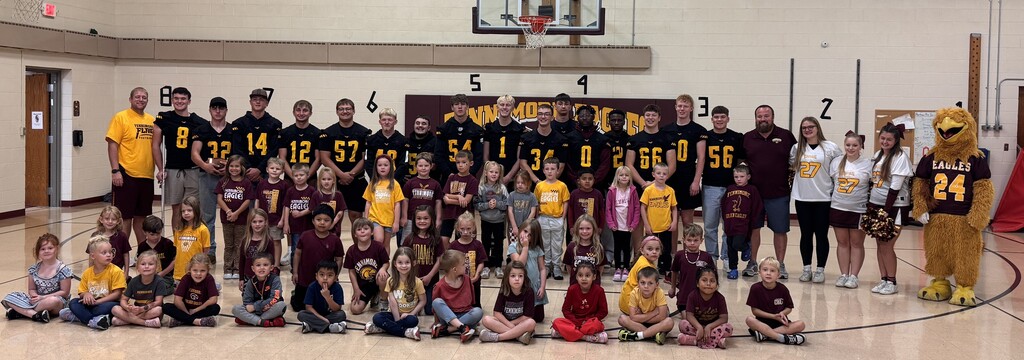 players, coaches, cheer squad, screech the mascot and 5K students pose for a picture