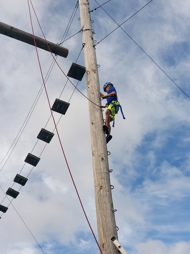 a student is in the harness and climbing at bethel horizons field trip