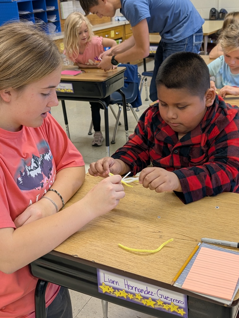 A ffa student helps a younger student make their spider sucker