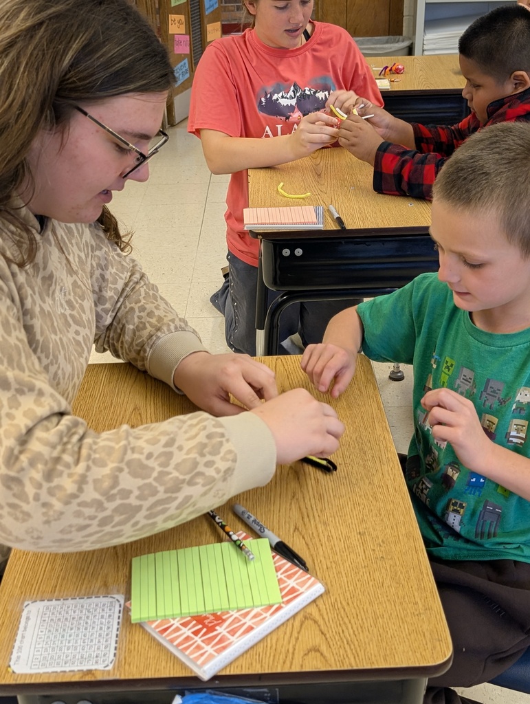A ffa student helps a younger student make their spider sucker