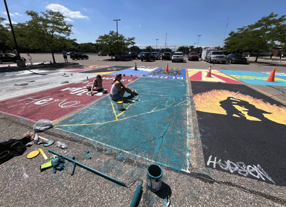 students paint parking spaces