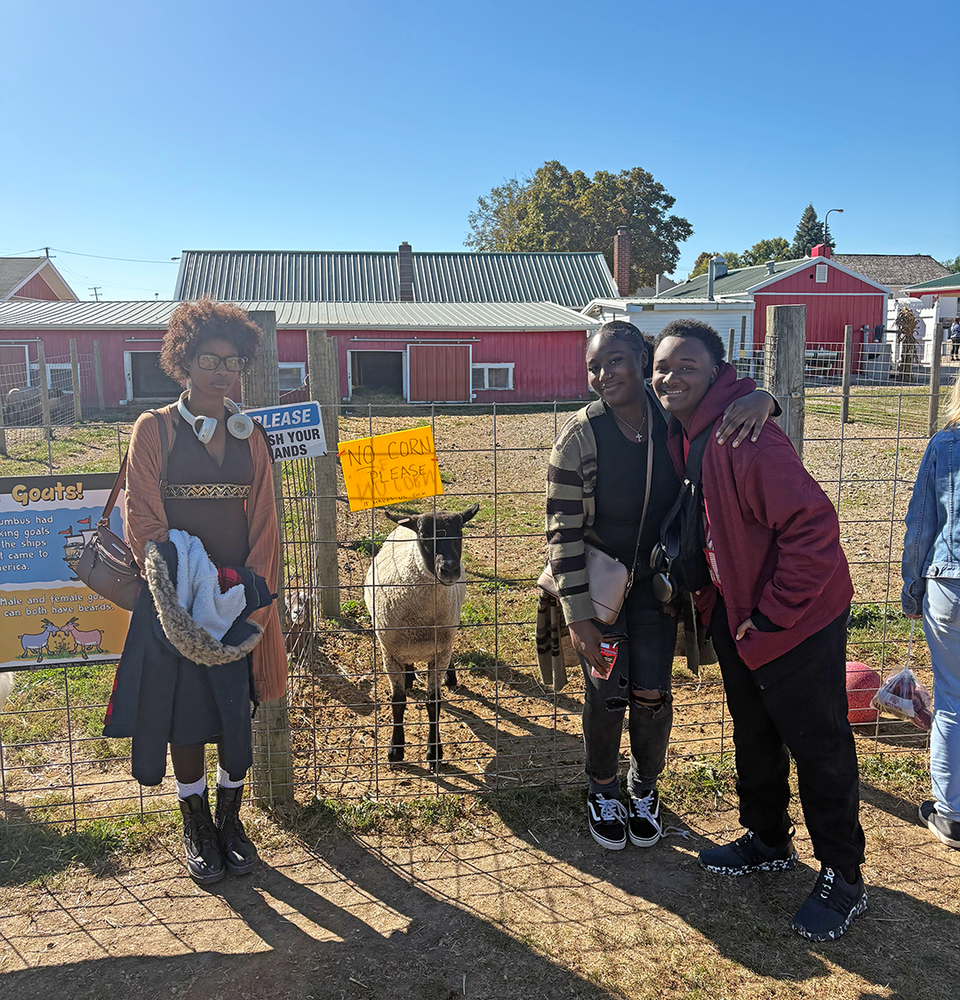 students at cider mill with a goat