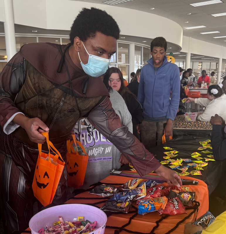 students collect candy and treats in the nest during Harvest Festival.
