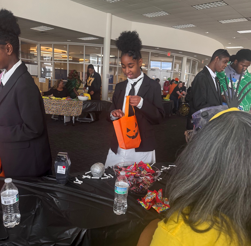 students collect candy and treats in the nest during Harvest Festival.