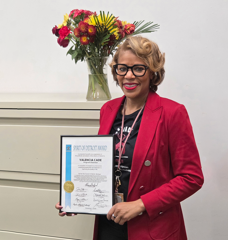 valencia Cade holds her spirit of detroit award certificate