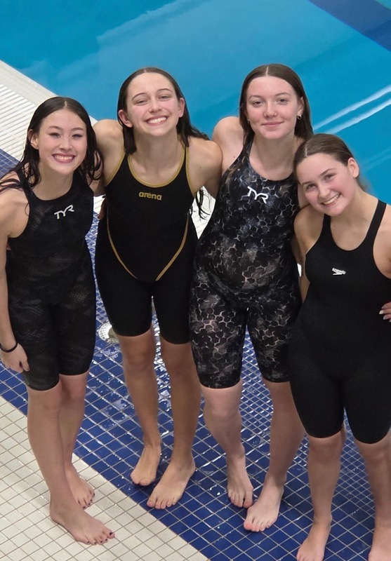 swimmers pose poolside