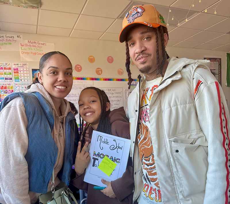 Students sign copies of the books they wrote and published.