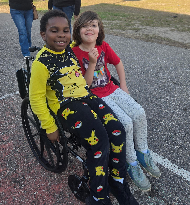 students in Cub Scouts at FUEL practice  using assistive devices to learn empathy for persons living with disabilities