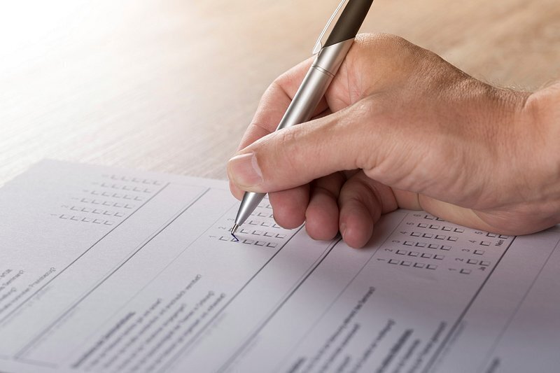 picture of hand with pen completing a paper form