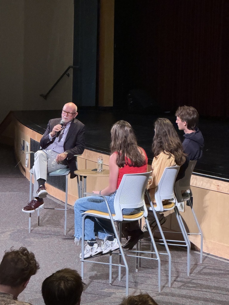 students with adult presenter in theater