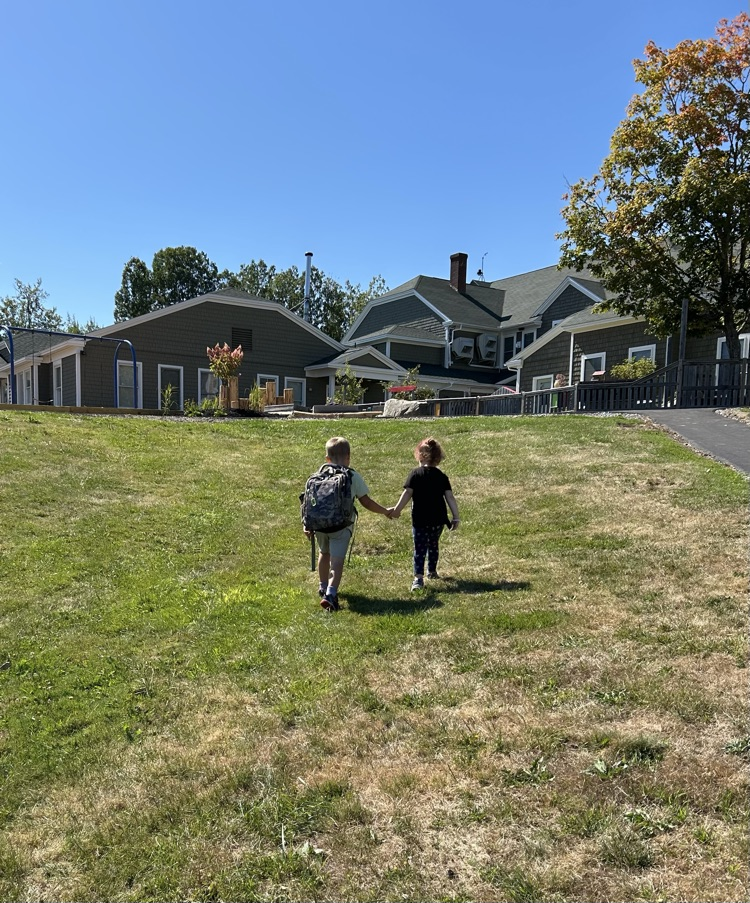 two students walking up a hill