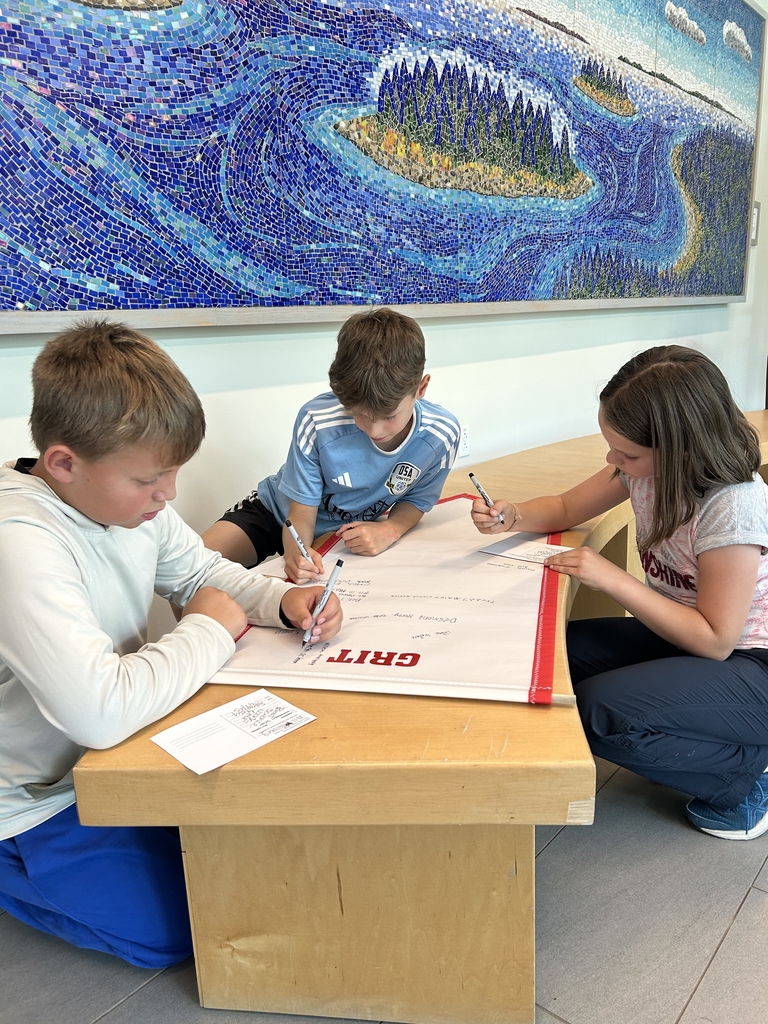 students signing grit poster