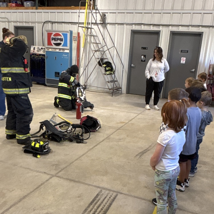 Heidi and Ryan putting on their fire suits