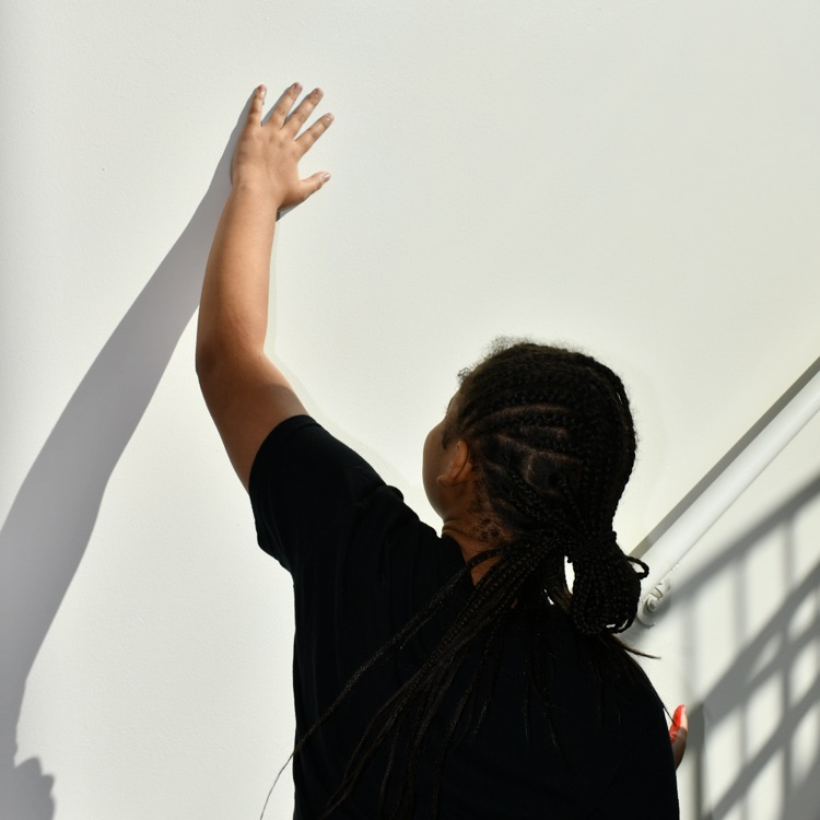 scholars adding handprints to the cube mural