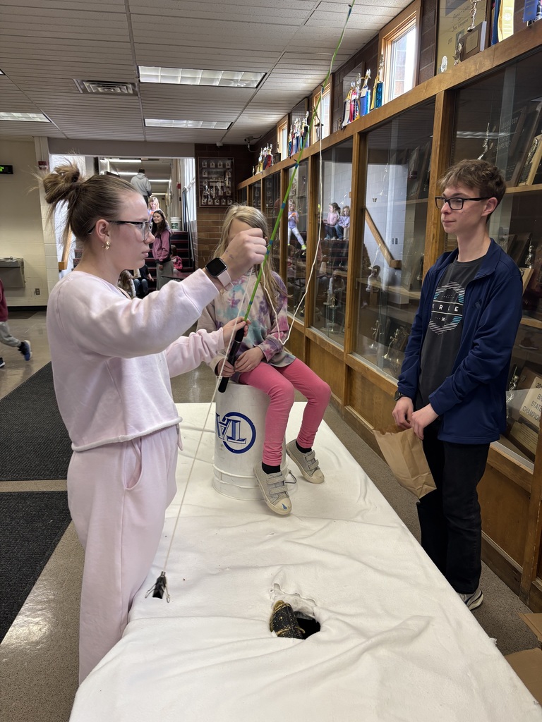 students helping a child pretend to fish