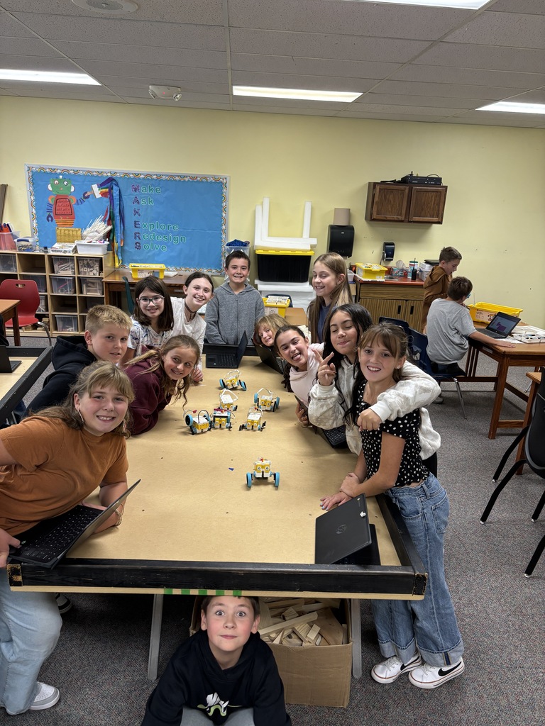 students around a table with robot builds on them