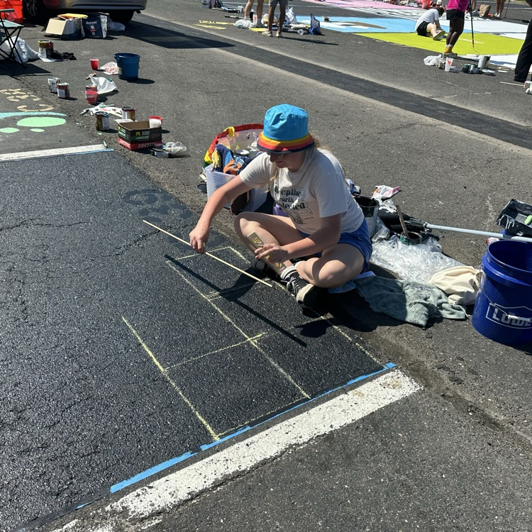 Picture of a girl painting a parking spot