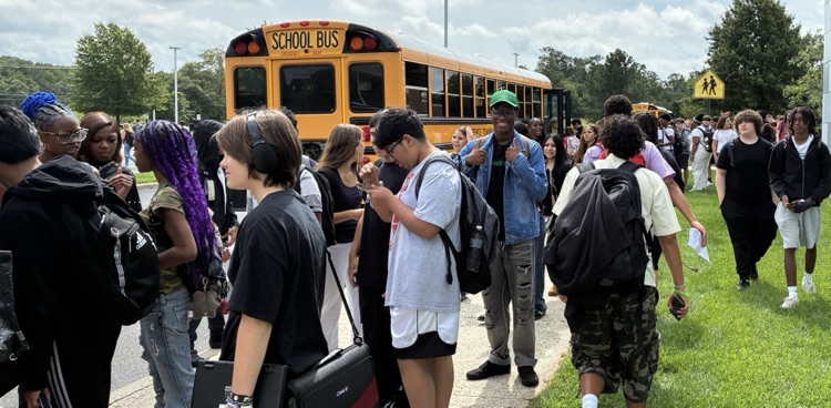 High school student standing outside waiting for the bus