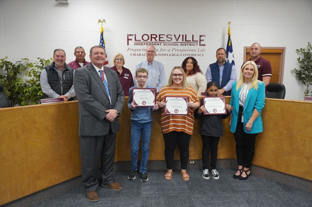 Students and teacher holding certificate in front of board members