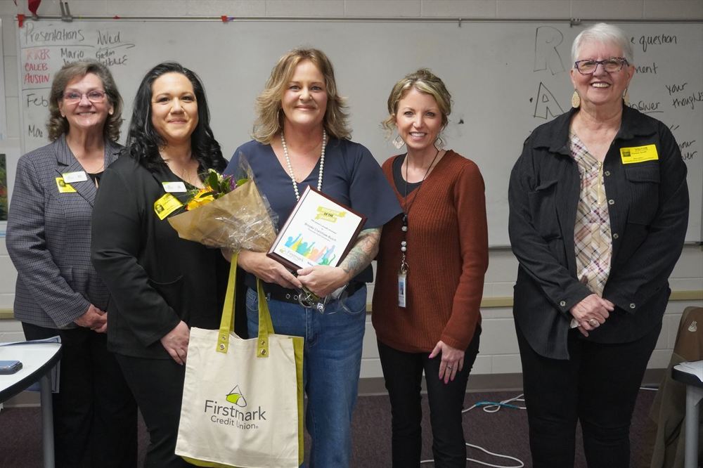 five women standing next to each other in classroom