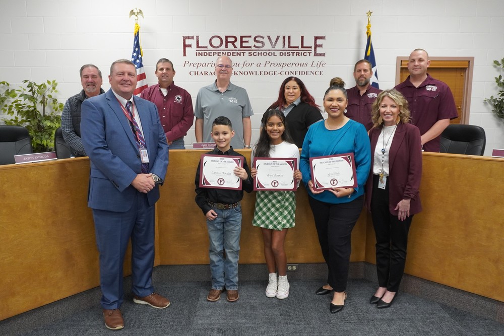 Students and teacher holding certificate in front of board members