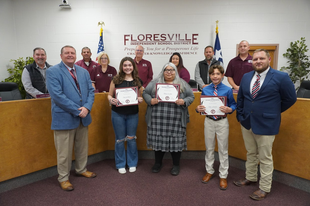 Students and teacher holding certificate in front of board members