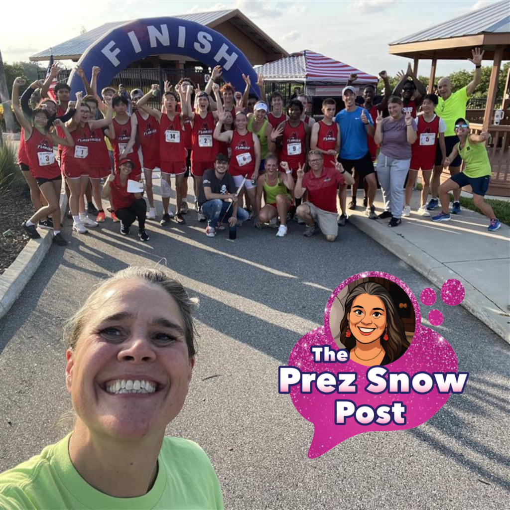 President Tracie Snow is taking a selfie with the cross country team at the end of their race. 