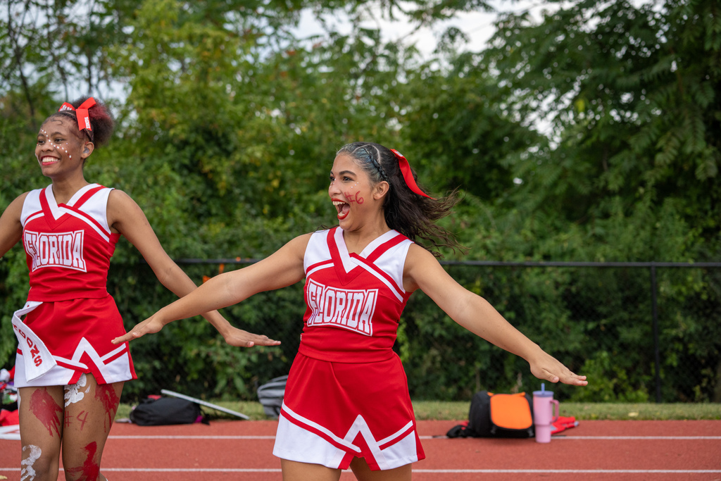 An FSDB cheerleader clap her hands and smile while cheering for the football team. 