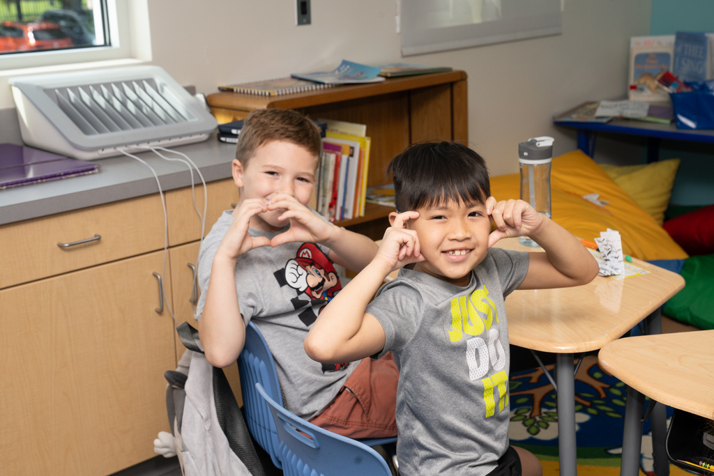 Two 2nd grade students pose for a photo inside the classroom.