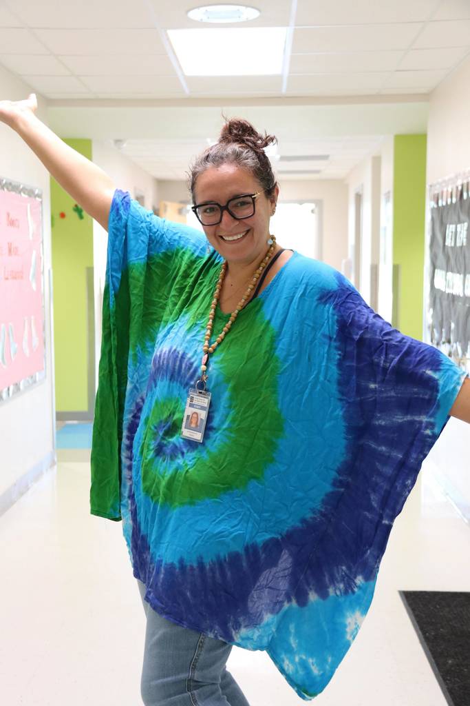 A staff member is wearing a tie dye color of blue and green resembling one of the element colors. 