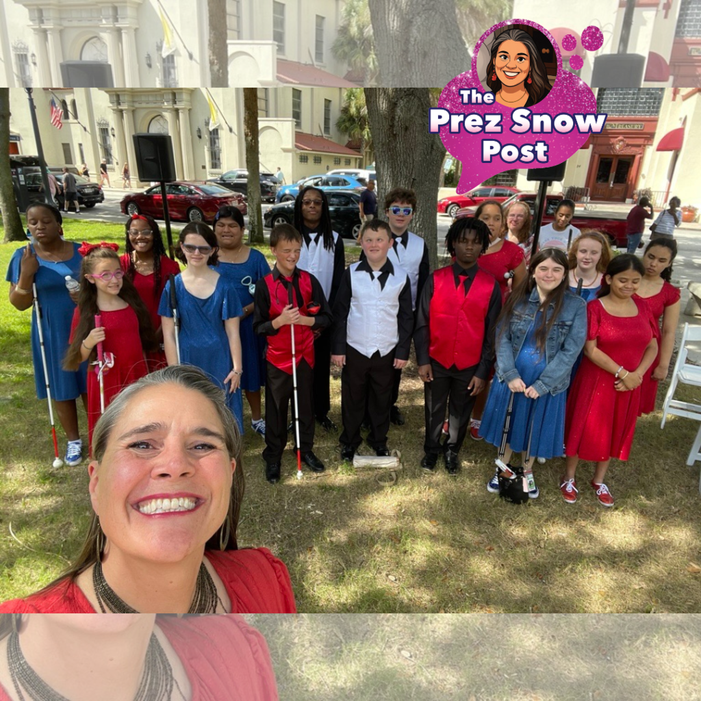 President Snow is taking a selfie and smiling with the Blind Department Show Choir outside downtown St. Augustine. 
