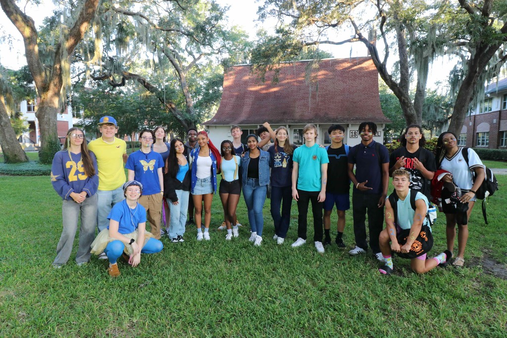Group of seniors smiling for a photo with their class colors, blue and yellow clothing. 