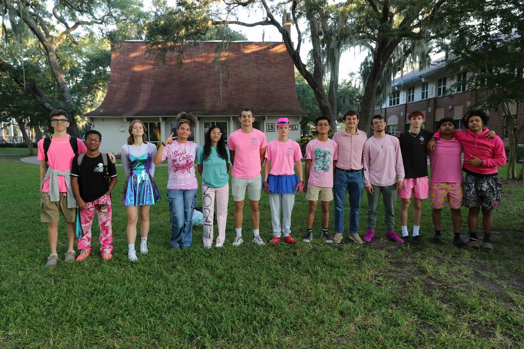Group of students wearing their class color clothing color pink smiling for a group outside of Pope. 