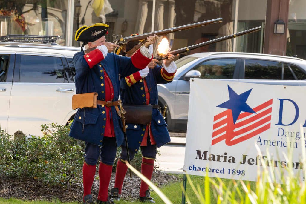 A photo of two St. Augustine members dressed as soldiers shooting the gun outside the plaza in downtown St. Augustine. 