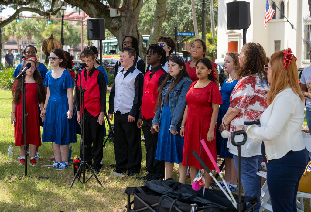 Group of blind students wearing red, white and blue clothing singing on the plaza in downtown St. Augustine. 