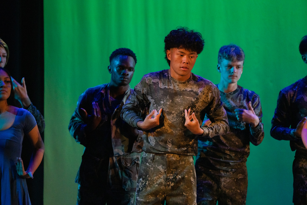 A dance troupe student wearing camo dancing on stage in Kirk. 