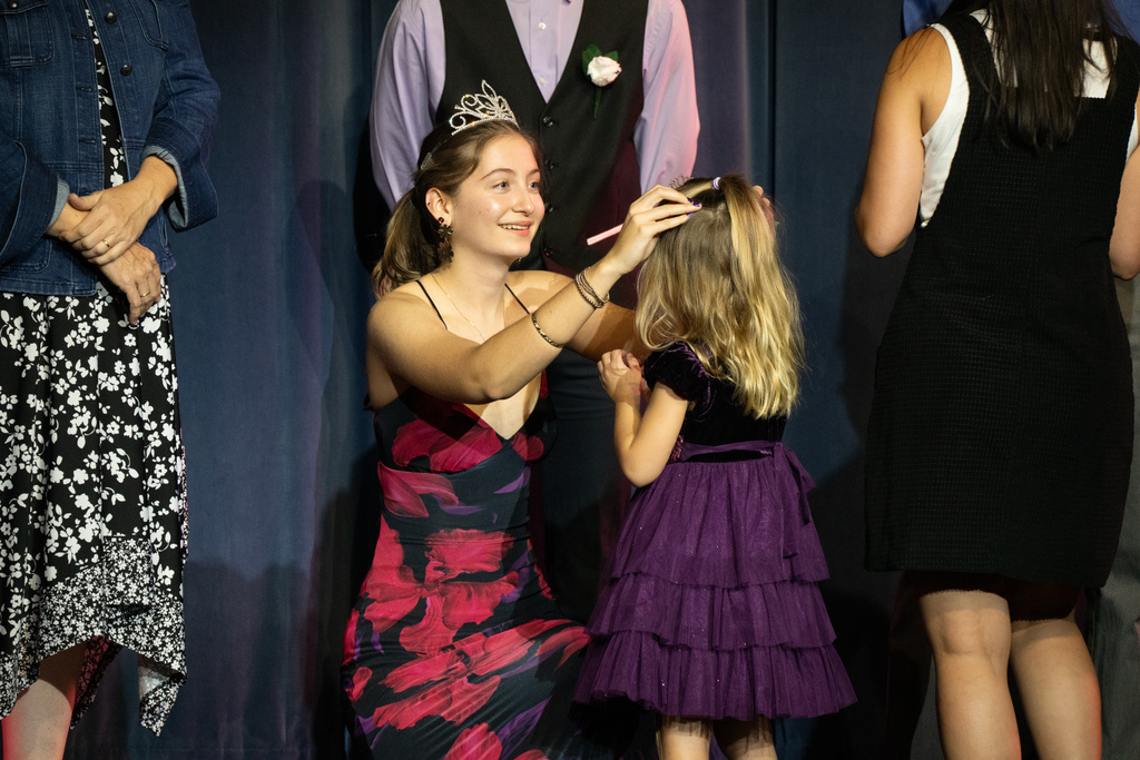 The Homecoming Queen hands the ELC student her princess crown as she becomes the Homecoming Queen. 