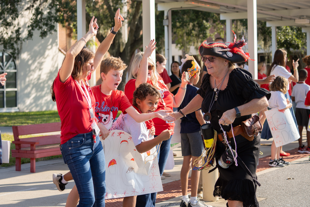 Students high five a woman dressed up as a pirate during the parade. 