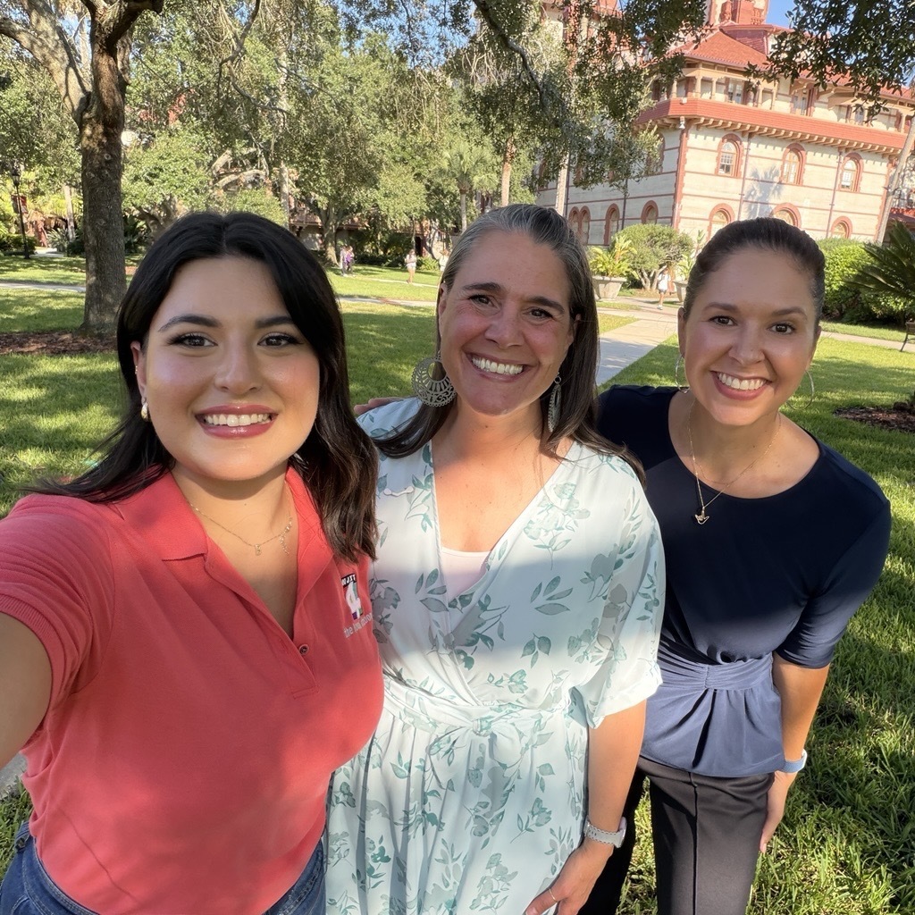 Left to right: News4Jax anchor, President Tracie Snow, and Alvina, Interpreter, smile for a selfie on the campus lawn of Flagler College. 