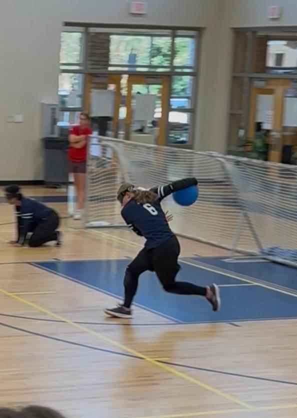 Lily, playing center, is about to throw the ball across the court.