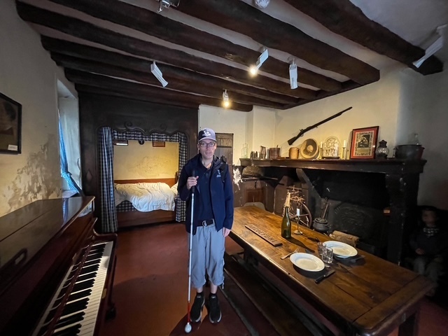 Photo of Mr. Ferguson smiling for his photo inside the home of Louis Braille. 