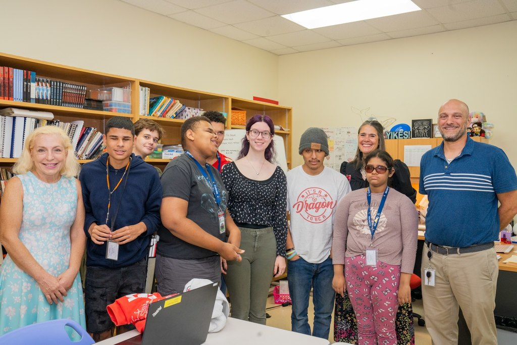 The Blind Principal, BHS Assistant Principal , President Snow, Hannah and her students smile for a photo inside her classroom.