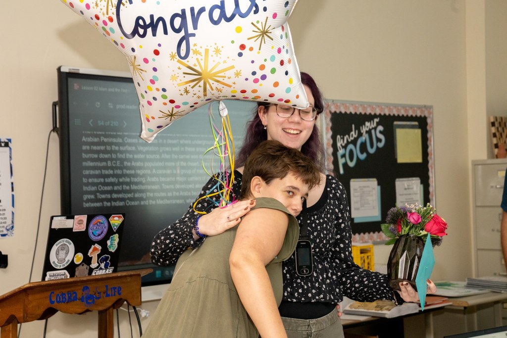 A blind student hugs Hannah.