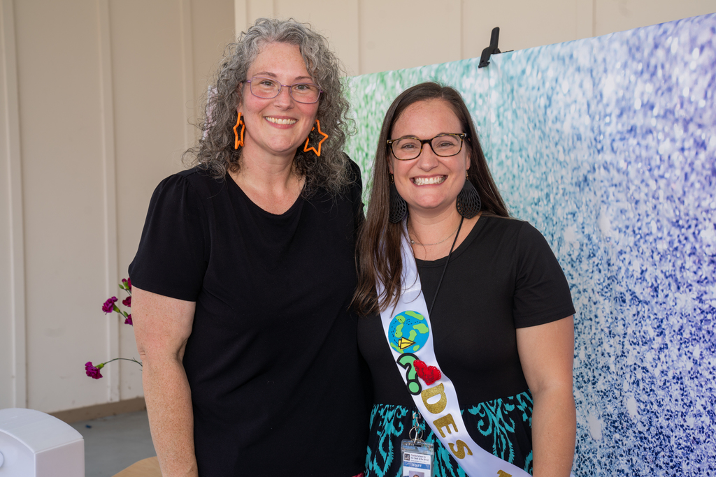Last year's Teacher of the Year smile with the new Teacher of the Year for a photo together.
