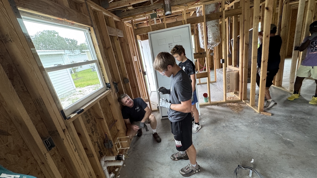 FSDB students working on construction inside a house with their teacher.