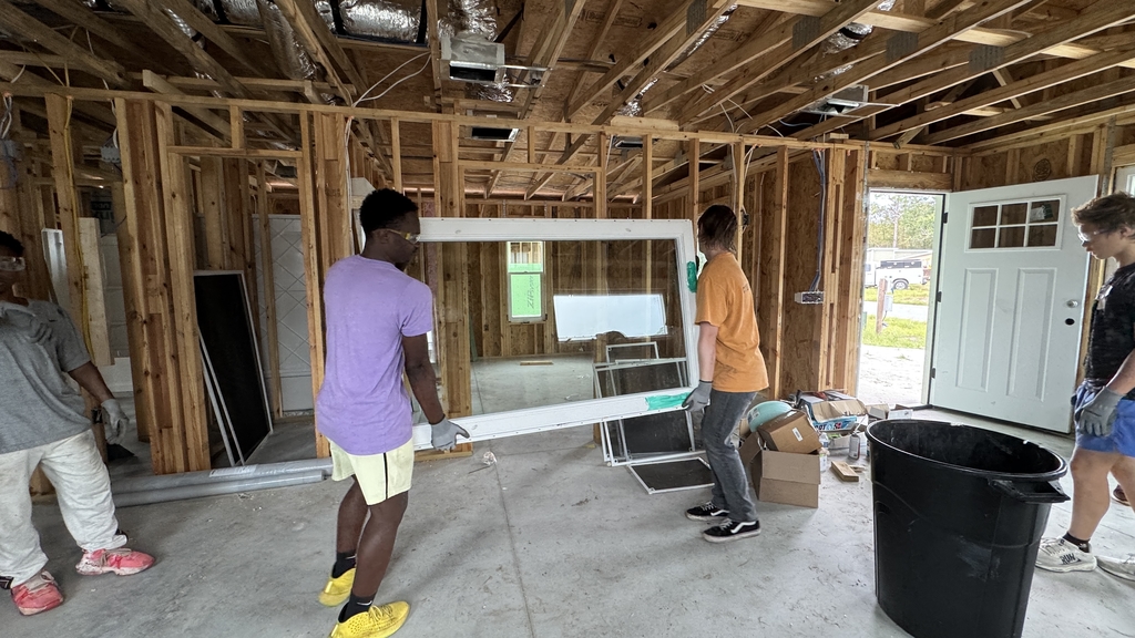 FSDB students carrying material to where it should be in the house they are building.