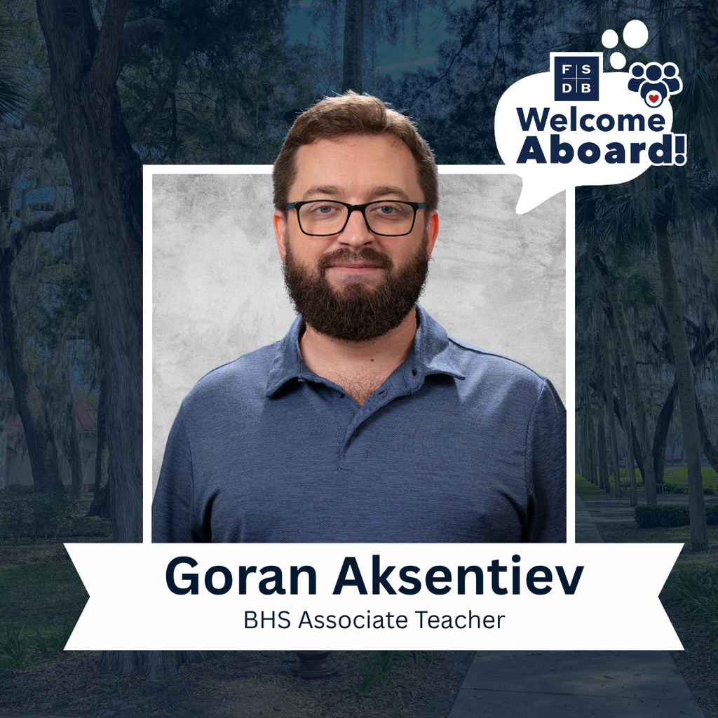 Goran is wearing a light blue collar shirt smiling for his photo with a silver backdrop and blue background. Below the photo is a white textbox that says "Goran Aksentiev, BHS Associate Teacher"